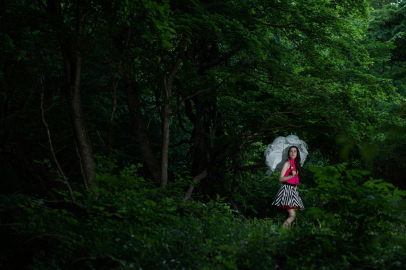 Amostra de imagem de uma mulher na floresta com um guarda-chuva